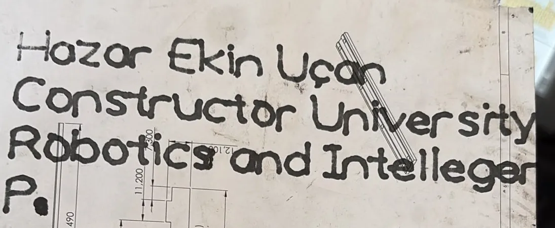The same four lines written in pen on paper by the robot, the strokes visibly formed from straight segments.